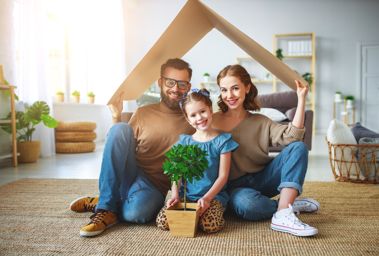 concept housing   young family. Mother father and child in new house with  roof at home